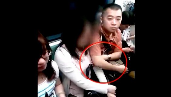 上海地下鉄の痴漢行為：男性が女性の胸を触った瞬間  
